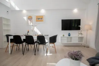 a white living room with a dining room table and chairs at Gran Chalet con Piscina (8-10 pp) in La Eliana