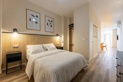 a bedroom with a large white bed and a wooden floor at Pivote Flats - Marina B in Valencia