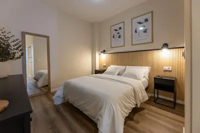a bedroom with a large white bed and a mirror at Pivote Flats - Marina B in Valencia