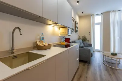 a kitchen with a sink and a living room at Pivote Flats - Marina B in Valencia