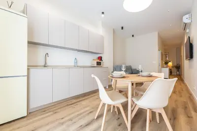 a kitchen and dining room with a table and chairs at Pivote Flats - Marina A in Valencia