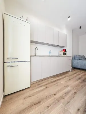 a kitchen with white cabinets and a refrigerator at Pivote Flats - Marina A in Valencia