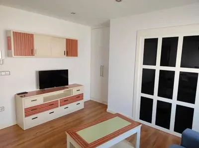 a living room with a flat screen tv and a table at Piso cerca universidades y playa in Valencia