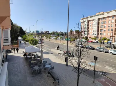 a city street with tables and chairs on a sidewalk at Piso cerca universidades y playa in Valencia