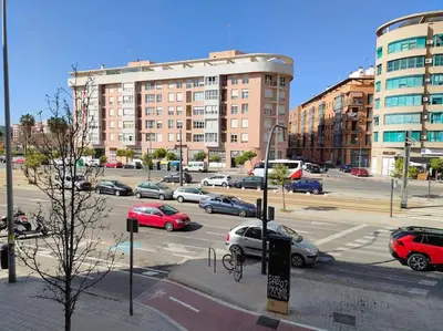 a city street with cars parked in a parking lot at Piso cerca universidades y playa in Valencia