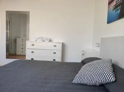a bedroom with a bed and a dresser at Piso cerca universidades y playa in Valencia