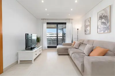 a living room with a couch and a flat screen tv at ApartUP Patacona Paradise Duplex in Valencia