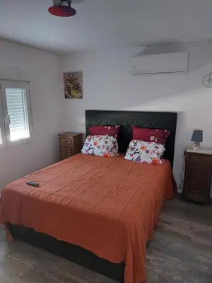 a bedroom with a large bed with orange sheets and pillows at les berreries in Montroy