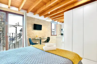 a bedroom with a large bed and a kitchen at Apartamento de diseño en la Plaza del Carmen F1 in Valencia