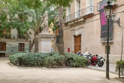 a motorcycle parked next to a statue of a woman at Apartamento de diseño en la Plaza del Carmen F1 in Valencia