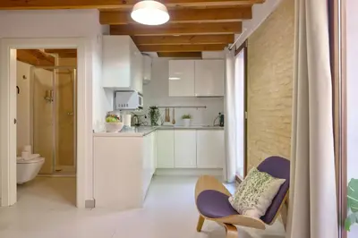 a kitchen with white cabinets and a purple chair at Apartamento elegante en Plaza del Carmen F2 in Valencia