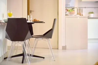 a table with two black chairs in a kitchen at Apartamento elegante en Plaza del Carmen F2 in Valencia
