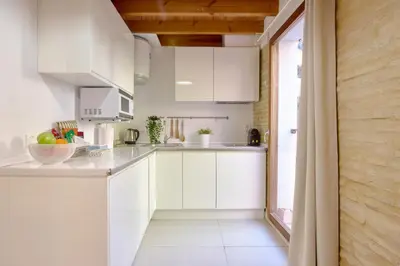 a kitchen with white cabinets and a large window at Apartamento elegante en Plaza del Carmen F2 in Valencia
