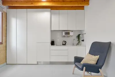 a living room with a chair and a kitchen at Loft elegante en Plaza del Carmen F3 in Valencia