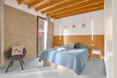 a bedroom with a blue bed and a chair at Apartamento de diseño en Plaza del Carmen F4 in Valencia