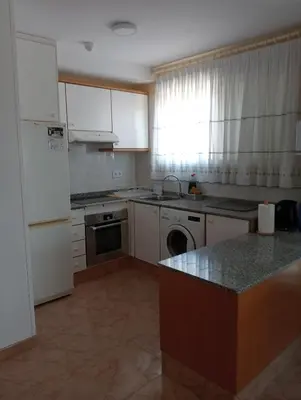 a kitchen with white cabinets and a dishwasher at CANETSOL in Canet de Berenguer
