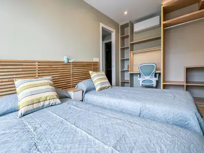 a bedroom with two beds and a chair at El Séptimo Cielo de la Bahía de los Naranjos - Primera Línea de Playa in Cullera