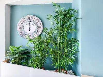 a clock on a blue wall next to two plants at El Séptimo Cielo de la Bahía de los Naranjos - Primera Línea de Playa in Cullera
