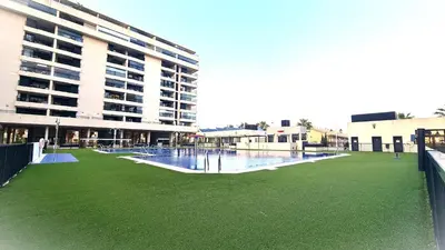 a large building with a green lawn in front of a building at BEACH VALENCIA LUXURY D9-29 Apartment with terrace and sea views with two rooms in Valencia