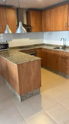 a kitchen with wooden cabinets and a counter top at Acogedor apartamento en la playa con WIFI y AACC in Moncófar