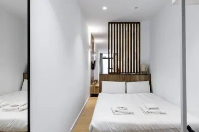 two beds in a room with two mirrors at VLC HOST - San Jacinto in Valencia