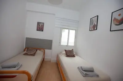 two twin beds in a room with a window at Precioso Apartamento en Valencia 2 dormitorios con Parking in Paterna