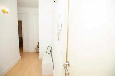a hallway with a white door and a wooden floor at Precioso Apartamento en Valencia 2 dormitorios con Parking in Paterna