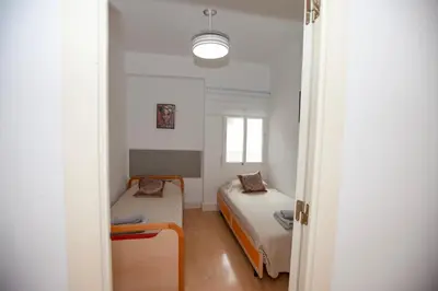 a small room with two beds and a window at Precioso Apartamento en Valencia 2 dormitorios con Parking in Paterna