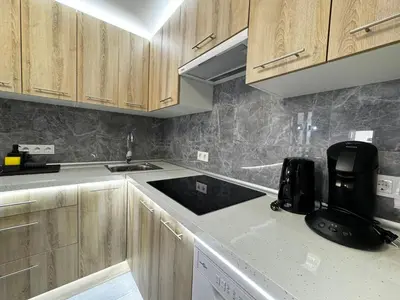 a kitchen with wooden cabinets and a counter top at Oriola 35 in Valencia