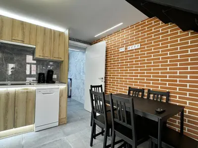 a kitchen with a table and chairs and a brick wall at Oriola 35 in Valencia