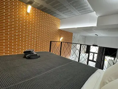 a bed in a room with a brick wall at Oriola 35 in Valencia