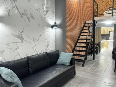 a black leather couch in a room with a marble wall at Oriola 35 in Valencia