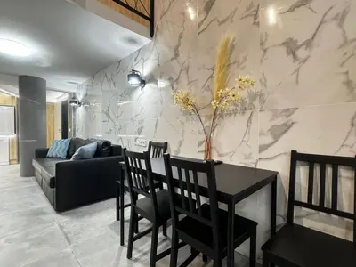 a living room with a couch and a table and chairs at Oriola 35 in Valencia