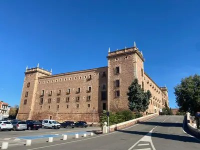 a large brick building with cars parked in a parking lot at Apartamento en primera línea de la playa a 15 minutos de la Ciudad de Valencia in Valencia