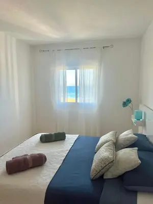 a bedroom with a large bed with a window at Apartamento en primera línea de la playa a 15 minutos de la Ciudad de Valencia in Valencia