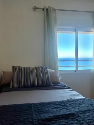 a bed with a window with a view of the ocean at Apartamento en primera línea de la playa a 15 minutos de la Ciudad de Valencia in Valencia