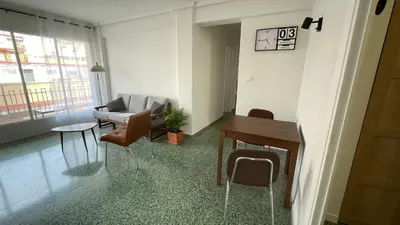 a living room with a couch and a table and chairs at Luminoso piso cerca de la playa in Cullera
