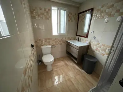 a bathroom with a toilet and a sink and a mirror at Luminoso piso cerca de la playa in Cullera