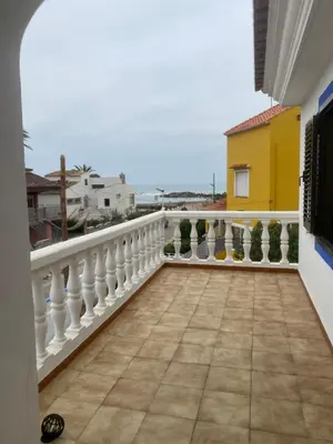 a balcony with a white railing and a yellow building at 1era linea de playa VILLA SALES Cullera Marenyet in Cullera
