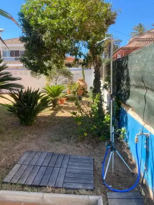 a wooden boardwalk next to a swimming pool with a light at 1era linea de playa VILLA SALES Cullera Marenyet in Cullera