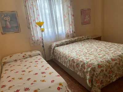a bedroom with two beds and a window at 1era linea de playa VILLA SALES Cullera Marenyet in Cullera