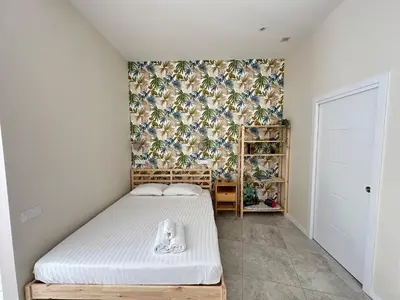 a small bedroom with a bed and a floral wallpaper at Calma Lofts in Valencia