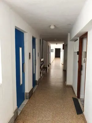 an empty hallway with blue doors and a tile floor at apartamento playa surf cullera in Cullera