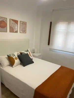 a bedroom with a white bed with pillows and a window at La Casa del Castell in Onda
