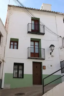a white building with windows and a door at La Casa del Castell in Onda
