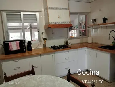 a kitchen with white cabinets and a microwave at Casa del Cerro in Eslida