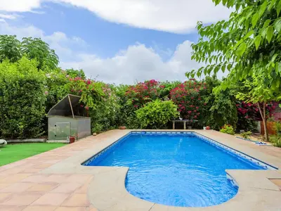 a swimming pool in a garden with flowers at Holiday Home D'estiu by Interhome in El Grao