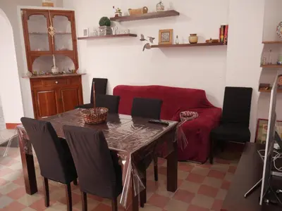 a living room with a table and a red couch at Casa Voramar in Cullera