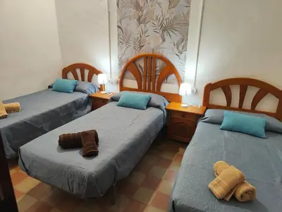 a room with two beds with towels on them at Casa Voramar in Cullera