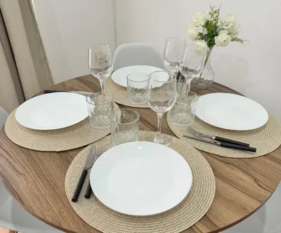 a wooden table with white plates and wine glasses at Apartamento en Valencia in Valencia